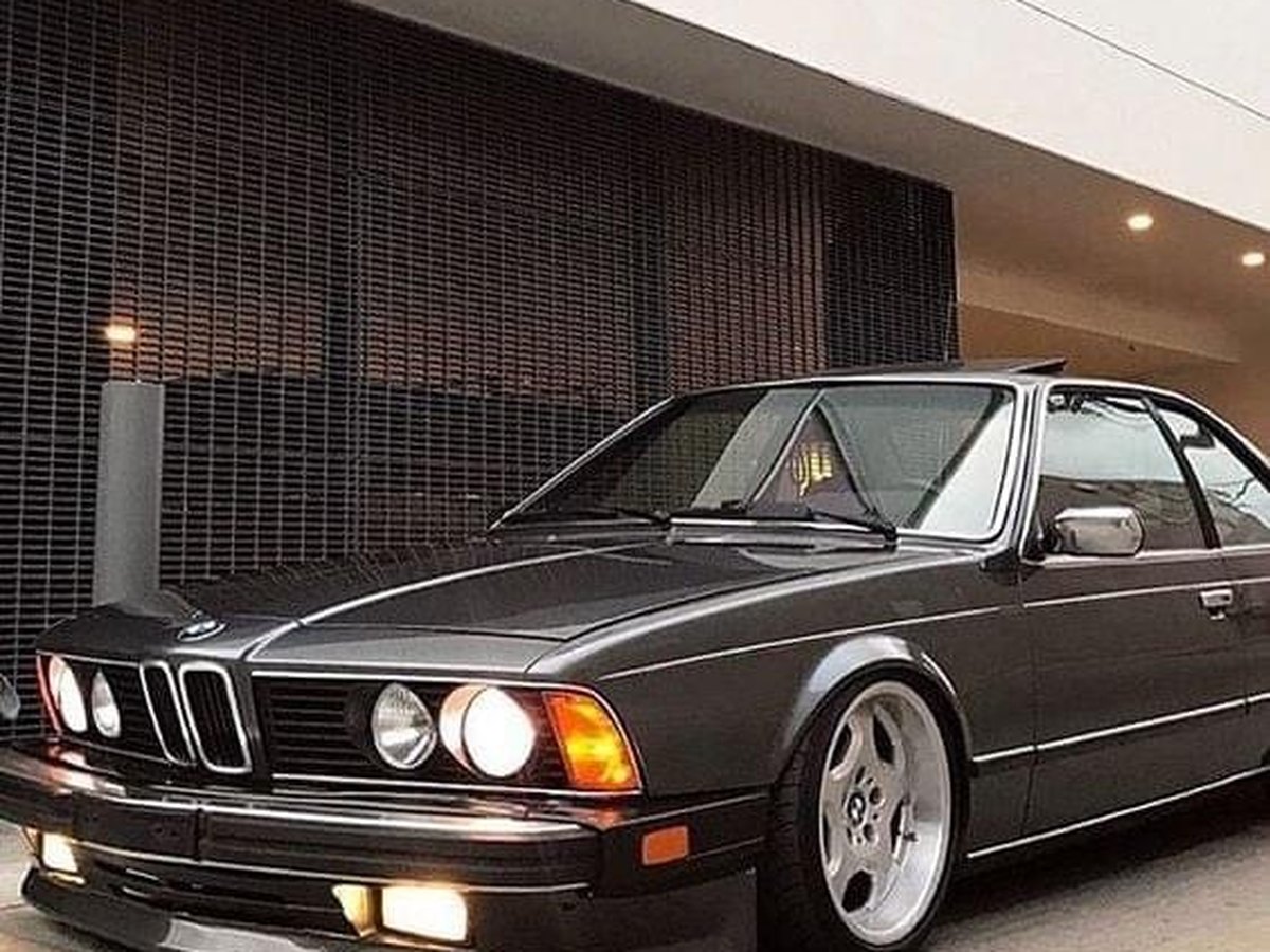 Classic BMW 6 Series coupe with lights on after full exterior detailing